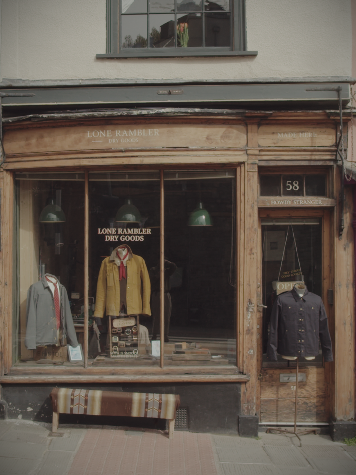 Exterior of shopfront with three mannequins displaying different jackets outside the entrance.