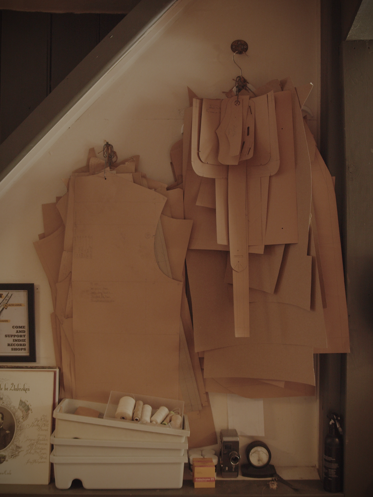 Workshop wall with paper patterns laid out for different jacket blocks and designs.